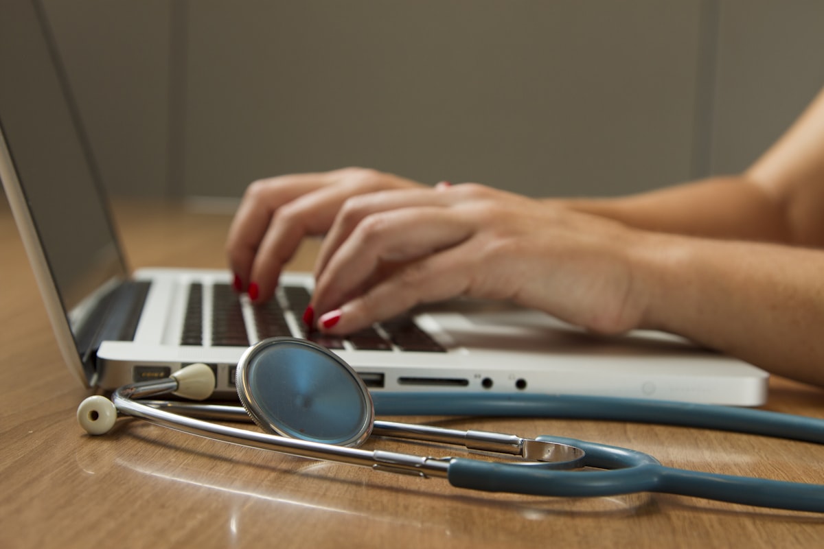 Doctor with stethoscope and tablet performing a Video Medical Examination Report (VMER) for health insurance underwriting